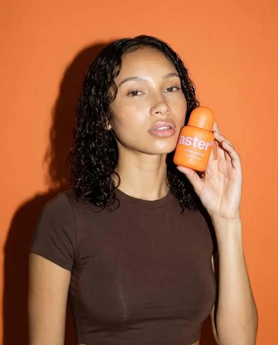aster* ad: a creator holding the serum