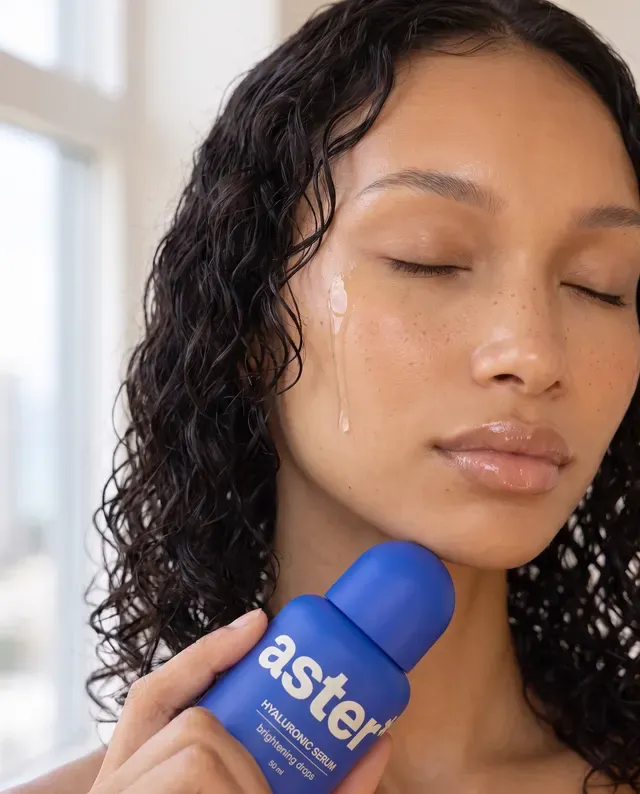 Video still, variant B: a creator pressing the blue serum to her cheek